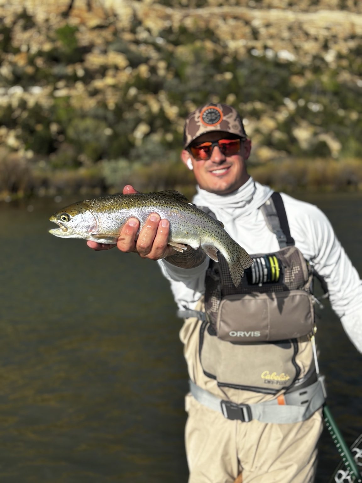 Angler presenting a rainbow trout toward the camera